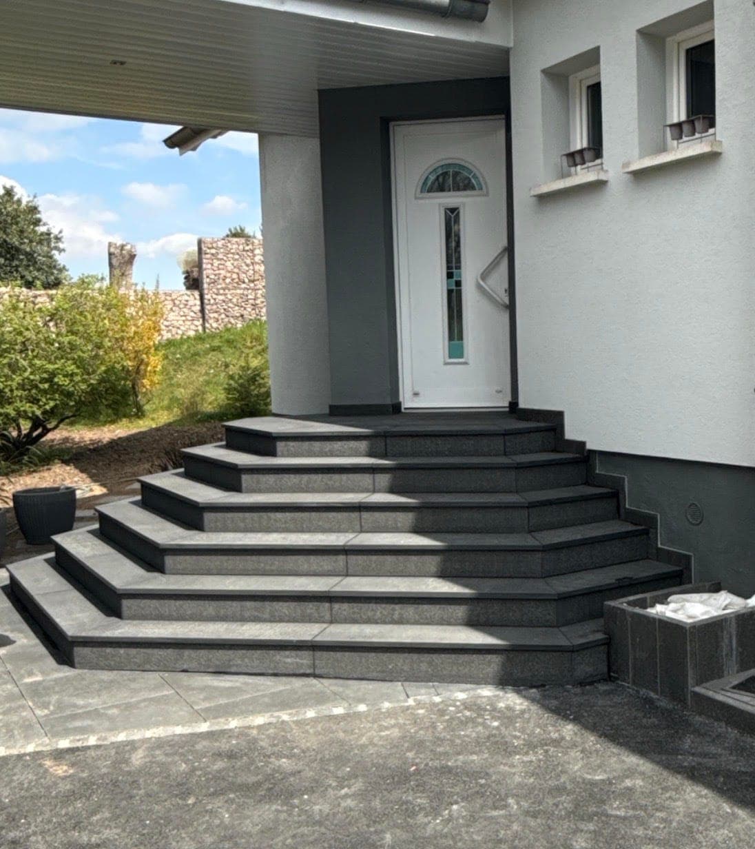 Escalier extérieur en granit noir, marches en éventail — réalisation CGM Alsace